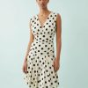 robes en tulle à pois courte moulante avec col v volanté sans manches couleur creme avec des motifs a pois noirs portée par une femme divine