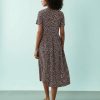 robes à pois filles longue mi tachetés marron et rose vue de dos sur un fond uni bleu clair avec une silhouette féminine et élégante