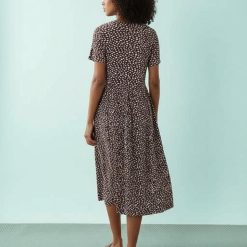 robes à pois filles longue mi tachetés marron et rose vue de dos sur un fond uni bleu clair avec une silhouette féminine et élégante