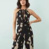 robes à pois années 50 noirs col bénitier profond longue imprimée godets contrastants portée par un mannequin sur un fond bleu clair