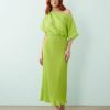robes asymétriques à pois citron vert métallisés épaule plissée longue dénudée portée par une femme rousse avec des sandales dorées