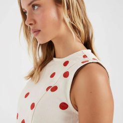 robes à pois rouge courte robe design rouges sans manches couleur ecru portee par une jeune femme vue de profil