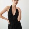 robes à petit pois noir dos nu et blanc portée par une jeune femme avec un décolleté en v