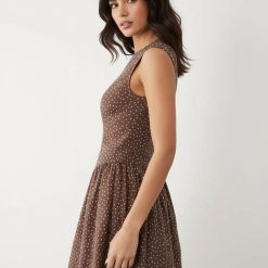 robes longues marron à pois ajustée basse surpiqûres taille sans manches pomme de pin portée par un mannequin de profil sur fond neutre