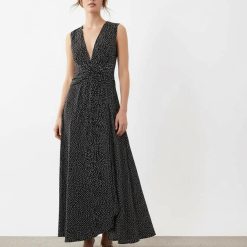 robes à pois blanc et noir froncée col longue v profond taille sans manches élégante et fluide portée par une femme