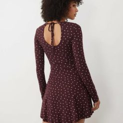 robes manches longues à pois violets bateau stretch patineuse courte encolure avec ouverture goutte d eau au dos et lien a nouer porte par un mannequin vue de dos
