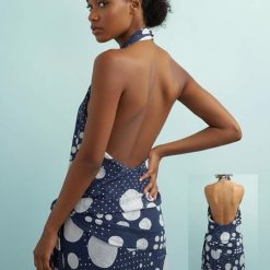 robes pin up à pois col halter taille basse longue noué bleu marine et blanc dos nu portée par un mannequin de profil montrant le motif imprimé