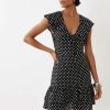 robes à pois noirs et blancs dos longue nu portée par une femme aux cheveux bouclés sur fond blanc