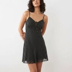 robes à pois chics mousseline courte bretelles en noir imprimée fluide moulante au niveau du buste avec petit noeud sur la poitrine