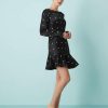 robes évasées à pois et manches courte en satin noire a volant portee par une femme sur fond bleu
