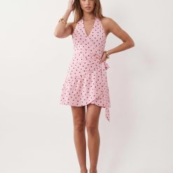 robes à pois transparentes portefeuille courte robe rose sans manches avec encolure halter et motif imprime de petits pois noirs sur fond rose clair