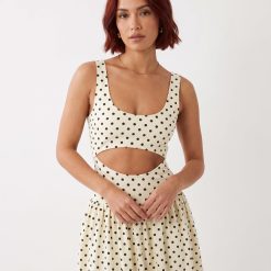 robes jaunes à pois découpes et détails longueur mollet couleur écru à petits pois noirs avec découpe sur la taille col décolleté sans manches