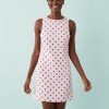 robes droites à pois roses en denim rayures portée par une femme souriante sur un fond bleu clair