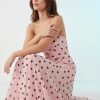 robes mousseline à pois en longue bandeau rose saxton longue robe fluide sans bretelles portée par une femme accroupie