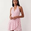 robes à pois transparentes portefeuille courte robe rose col halter avec volants au bas et noeud a la taille portee par une femme