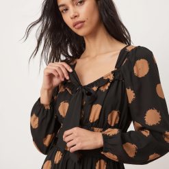 robes longues marron à pois bardot encolure avec nœud longueur mollet une jeune femme posant élégamment avec une robe élégante manches longues bouffantes