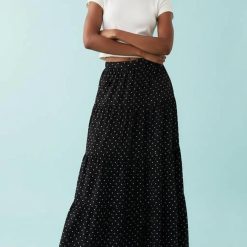 jupes longues à pois et volants étagés femme- noire imprimée de petits pois blancs portée avec un débardeur blanc