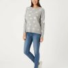 bonnets de nuit à pois gris en maille brossée porté par une femme avec un pull assorti et un jean bleu