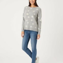 bonnets de nuit à pois gris en maille brossée porté par une femme avec un pull assorti et un jean bleu