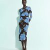 robes longues marron à pois fleurs tulle midi bleu moyen moulante à manches longues portée par un mannequin en sandales noires