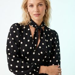 robes longues noires à pois blancs sadie col lavallière longueur mollet portée par une mannequin blonde aux cheveux ondulés avec manches longues