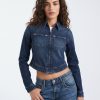jeans à pois style années 70 évasé bleu moyen porté par une femme avec une veste en jean courte bleu foncé