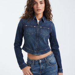 jeans à pois style années 70 évasé bleu moyen porté par une femme avec une veste en jean courte bleu foncé