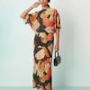 robes à pois jaune longue dénudées épaules plissée tilly multicolore portée par un mannequin avec un sac à main noir