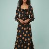 robes longues marron à pois bardot encolure avec nœud longueur mollet portée par un mannequin femme aux cheveux bruns robe noire imprimée de pois marron avec manches longues bouffantes