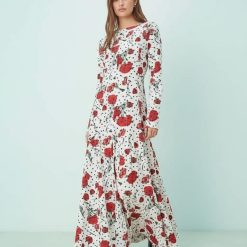 robes évasées à pois bateau encolure longue imprimé petites fleurs blanche à manches longues avec motifs de fleurs rouges portée par un mannequin
