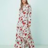 robes évasées à pois bateau encolure longue imprimé petites fleurs blanche à manches longues avec motifs de fleurs rouges portée par un mannequin
