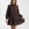robes longues marron à pois chocolat chemise taille basse courte une femme pose vêtue dune robe marron à pois blancs manche longue col chemise coupe ample pour un style décontracté et élégant