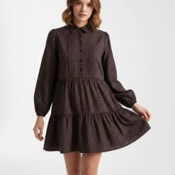 robes longues marron à pois chocolat chemise taille basse courte une femme pose vêtue dune robe marron à pois blancs manche longue col chemise coupe ample pour un style décontracté et élégant