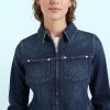 jeans à pois style années 70 évasé bleu moyen porté par une femme veste en jean bleu foncé fermeture éclair avec des poches sur la poitrine