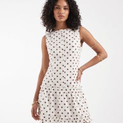 robes roses à pois blanc boutonnée courte crème portée par un mannequin avec bretelles et volant aux cuisses
