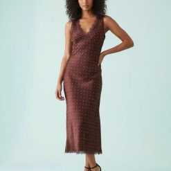 robes longues à pois rouge dentelle satin motif marron modèle féminin afro-américain posant en robe longue marron à pois rouges et dentelle élégante
