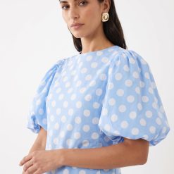 robes à pois jaune bleu clair avec manches bouffantes basse taille portee par une femme aux cheveux bruns et des boucles dorees
