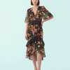 robes longues noires à pois fleurs basque imprimé taille haute avec col en v manches evasees et jupe a volants asymetrique motif floral multicolore sur mannequin