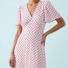 robes évasées à pois manches courtes col v rose marron imprimée de motifs bordeaux ajustée à la taille et portée par un mannequin avec des boucles d oreilles dorées